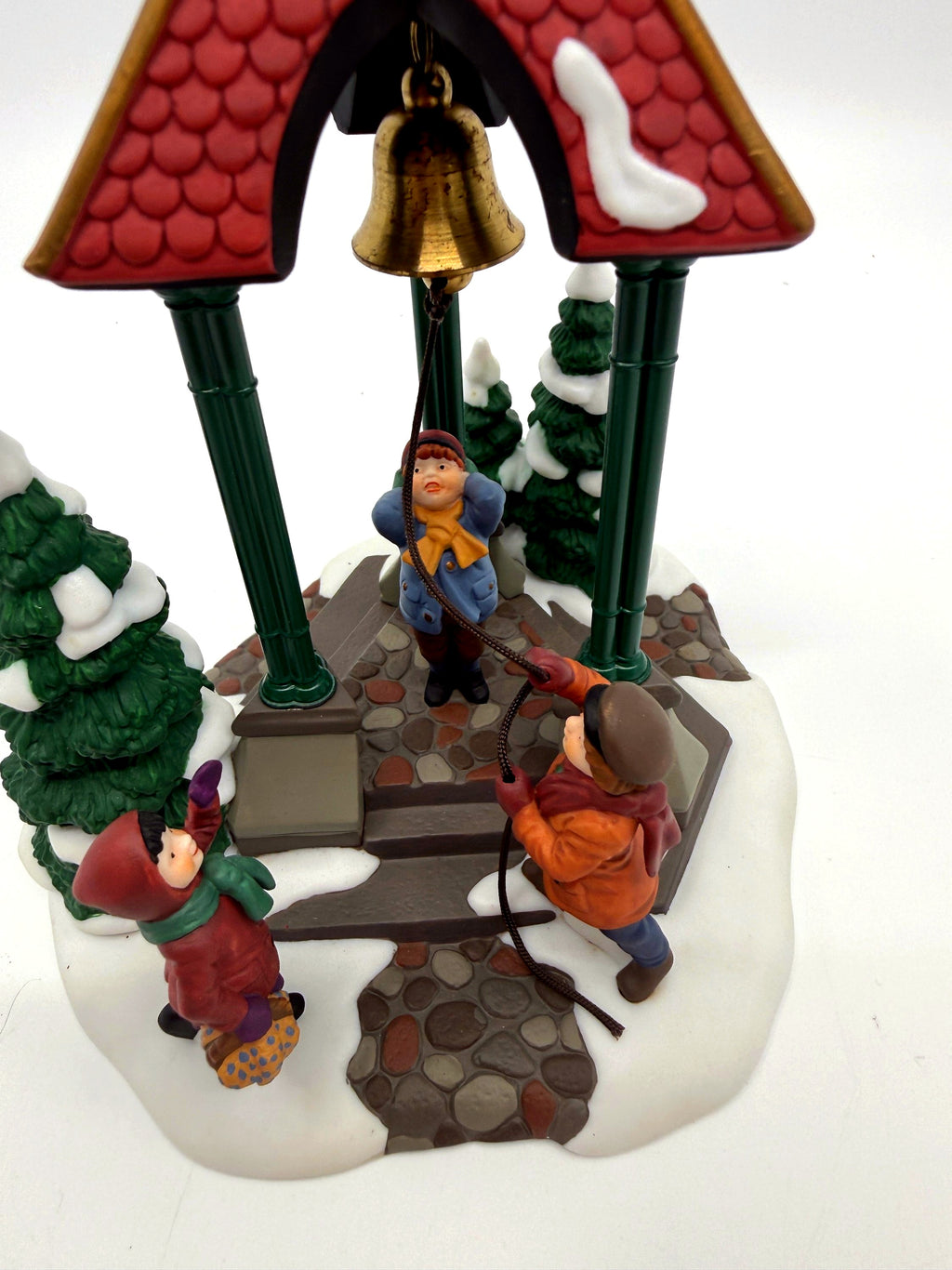 Department 56 Christmas Bells, 1996 Special Event Piece, Heritage Village Collection – close view: brass bell, rope and children beneath the pavilion roof