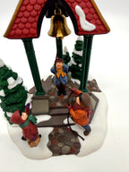 Department 56 Christmas Bells, 1996 Special Event Piece, Heritage Village Collection – close view: brass bell, rope and children beneath the pavilion roof