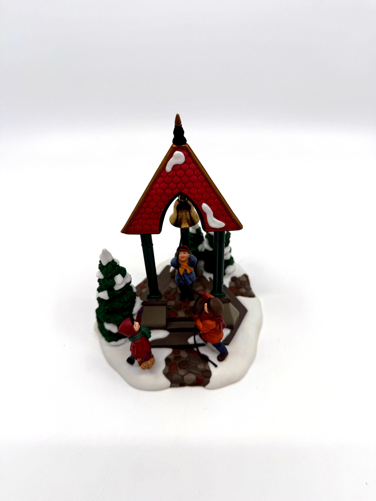 Department 56 Christmas Bells, 1996 Special Event Piece, Heritage Village Collection – angled view with evergreens