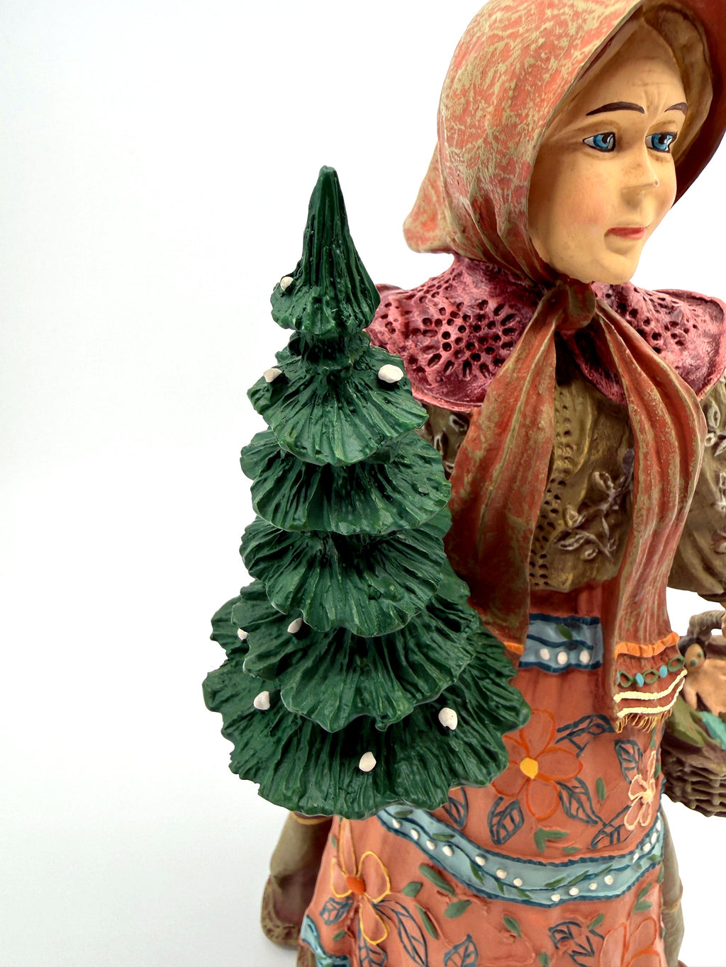 Babouska with snow-dusted evergreen tree, upper body close view (enhanced)