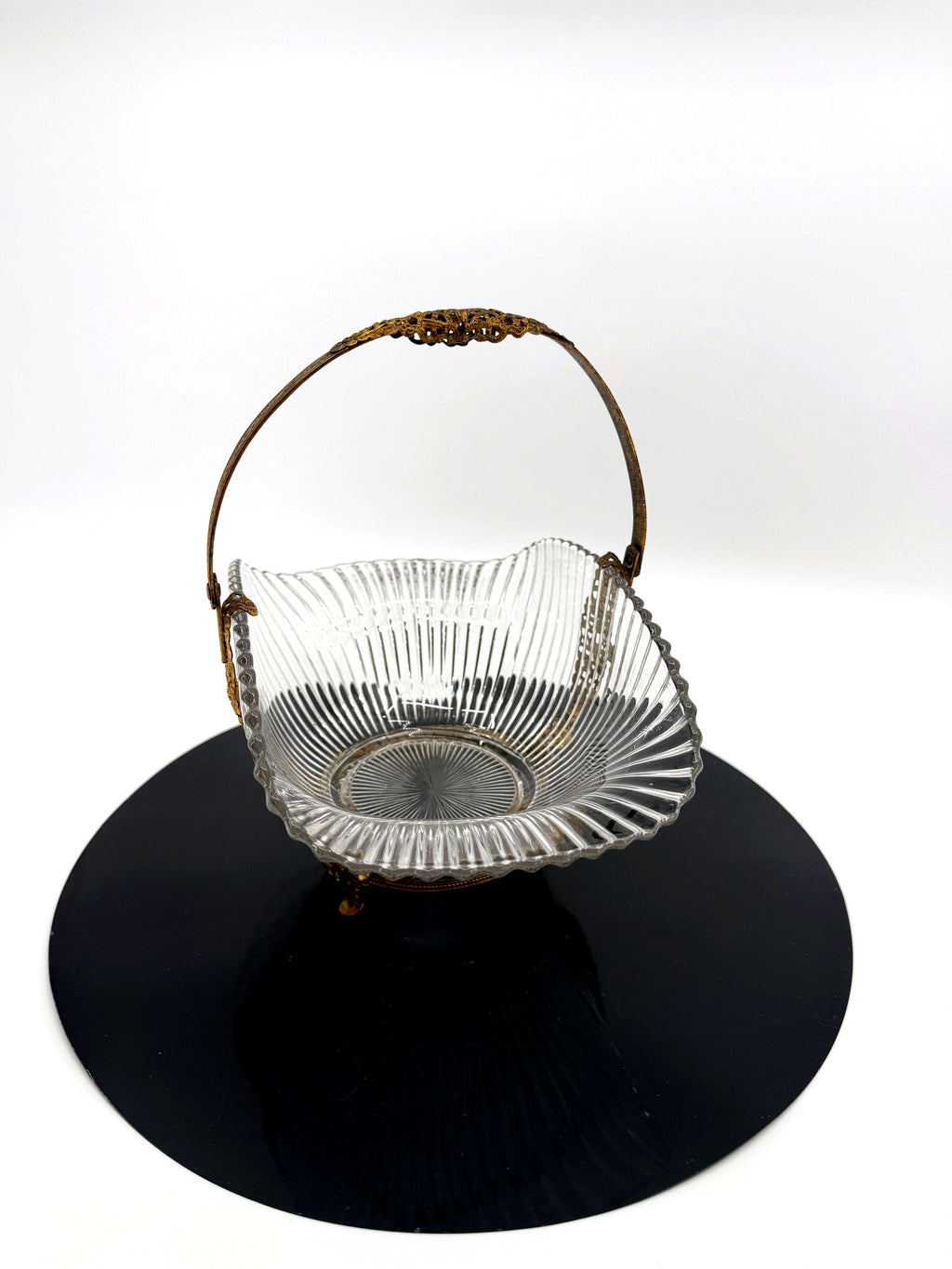 Vintage clear glass bride's basket with gold-tone filigree handle, front view (enhanced)