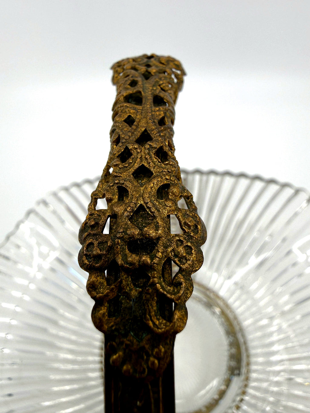 Close-up: pierced filigree handle grip with aged gold patina (enhanced)