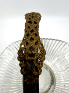 Close-up: pierced filigree handle grip with aged gold patina (enhanced)