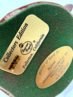 Underside: both gold identification plates on green felt base (enhanced)