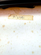 Close-up of the aged original paper backing with handwritten label