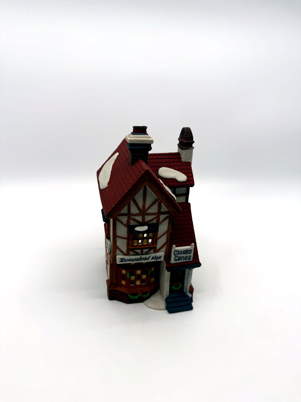 Front three-quarter view showing the half-timbered gable and snow-dusted red tile roof