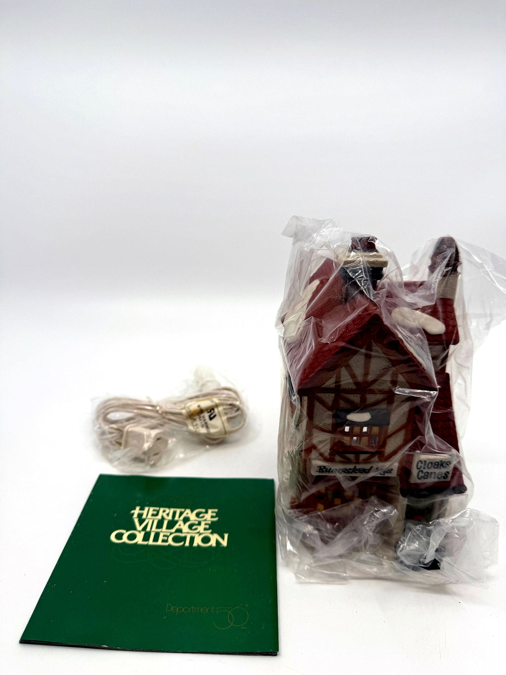 Included contents: the building in its protective bag, original lighting cord still sealed in its factory bag, and the Heritage Village Collection booklet