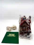 Included contents: the building in its protective bag, original lighting cord still sealed in its factory bag, and the Heritage Village Collection booklet