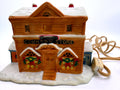 Lighted ceramic Christmas village country store, front view - tan storefront with COUNTRY STORE sign, wreath windows and snow-covered roof