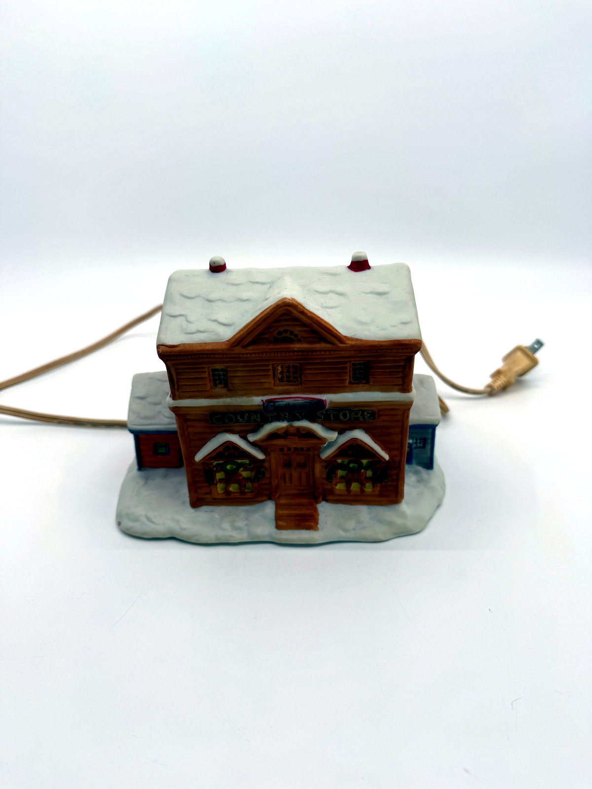Lighted ceramic Christmas village country store, straight front view with cord and plug