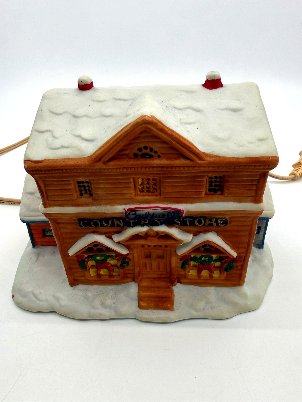 Lighted ceramic Christmas village country store, front detail view of the sign and wreath windows