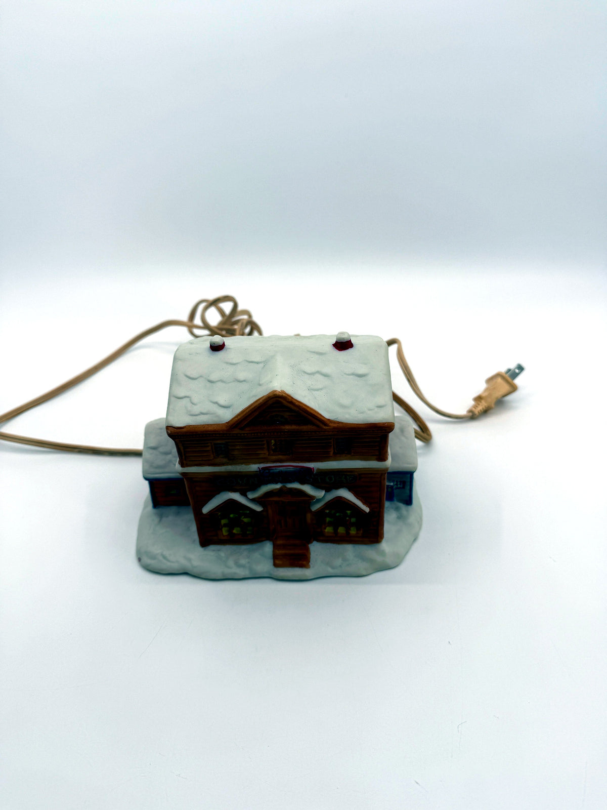 Lighted ceramic Christmas village country store, front view from above showing the snow-covered roof
