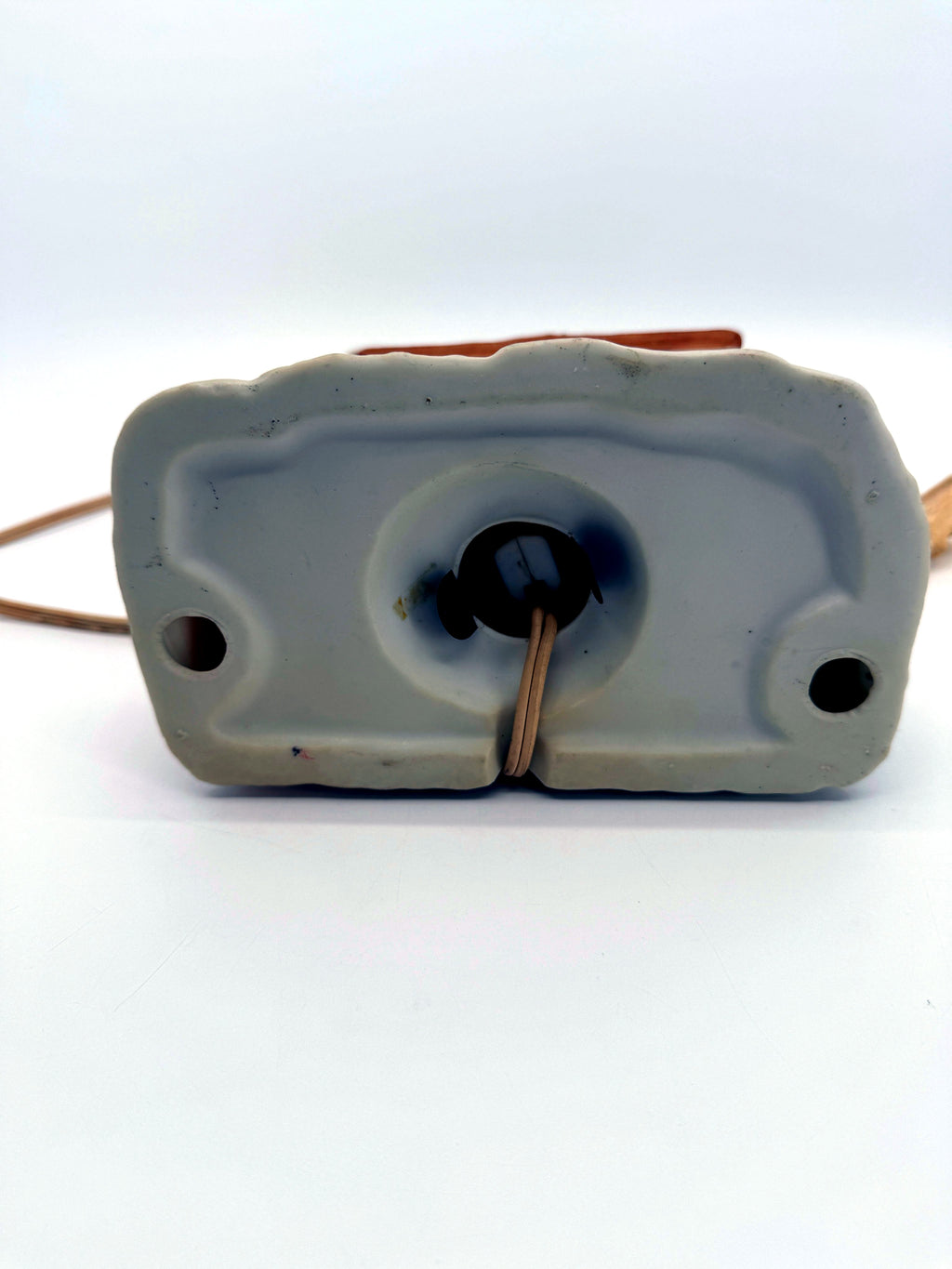 Lighted ceramic Christmas village country store, underside showing the light socket opening - unmarked base
