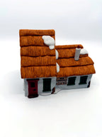 Front three-quarter view showing the tall thatched gable and the lower wing