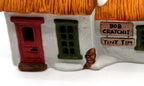 Detail of the hand-painted Bob Cratchit and Tiny Tim plaques beside the red front door