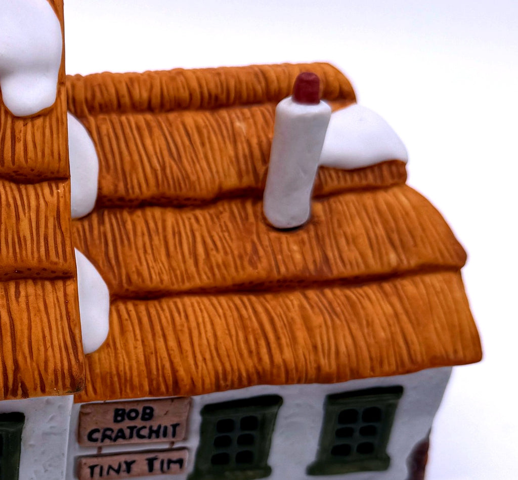 Detail of the textured thatched roof, sculpted snow and white chimney with red cap