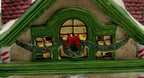Close-up of the attic window with Christmas wreath, red bow, and garland swags