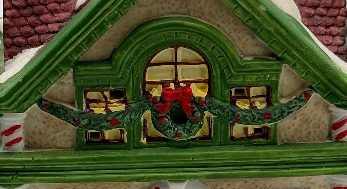 Close-up of the attic window with Christmas wreath, red bow, and garland swags