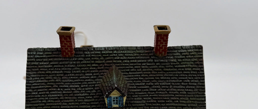 Close-up of the shingled roof, dormer, and brick chimneys