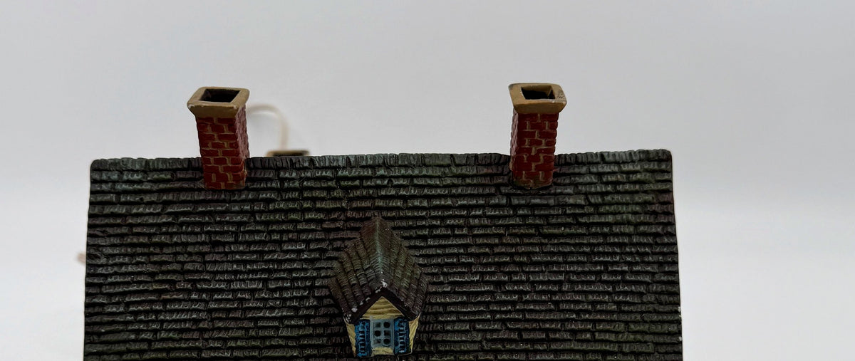 Close-up of the shingled roof, dormer, and brick chimneys