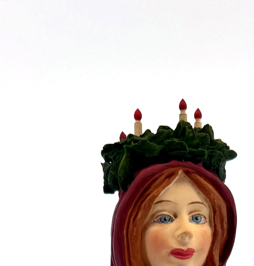Detail — the crown of candles set in greenery