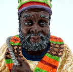 Detail crop — face, gray-flecked beard, jeweled crown and woven-pattern scarf