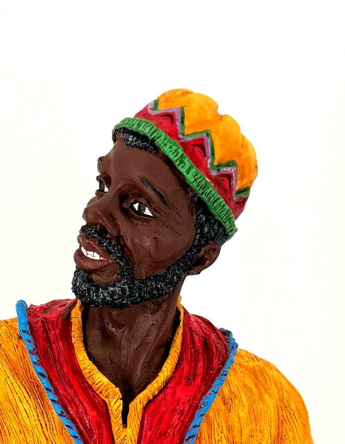 Detail crop — the male figure’s hand-painted face, gray-flecked beard and patterned cap