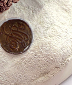 Detail: brass Duncan Royale medallion on the snowy base (detail from seller photo)