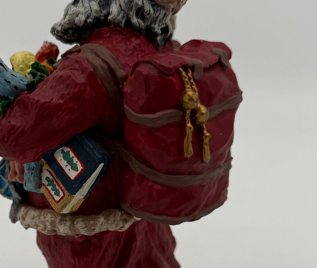Vintage 1991 Duncan Royale Today's Nast Santa figurine – detail of the red toy sack with gold bell tassels and the book tucked under his arm