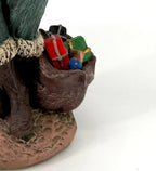 Close-up detail of the toy sack at the helper's feet, filled with tiny wrapped gifts and a blue ball