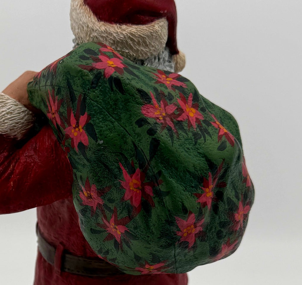 Vintage 1994 Duncan Royale Santa's Gift figurine – detail of the hand-painted poinsettia pattern on the gift sack