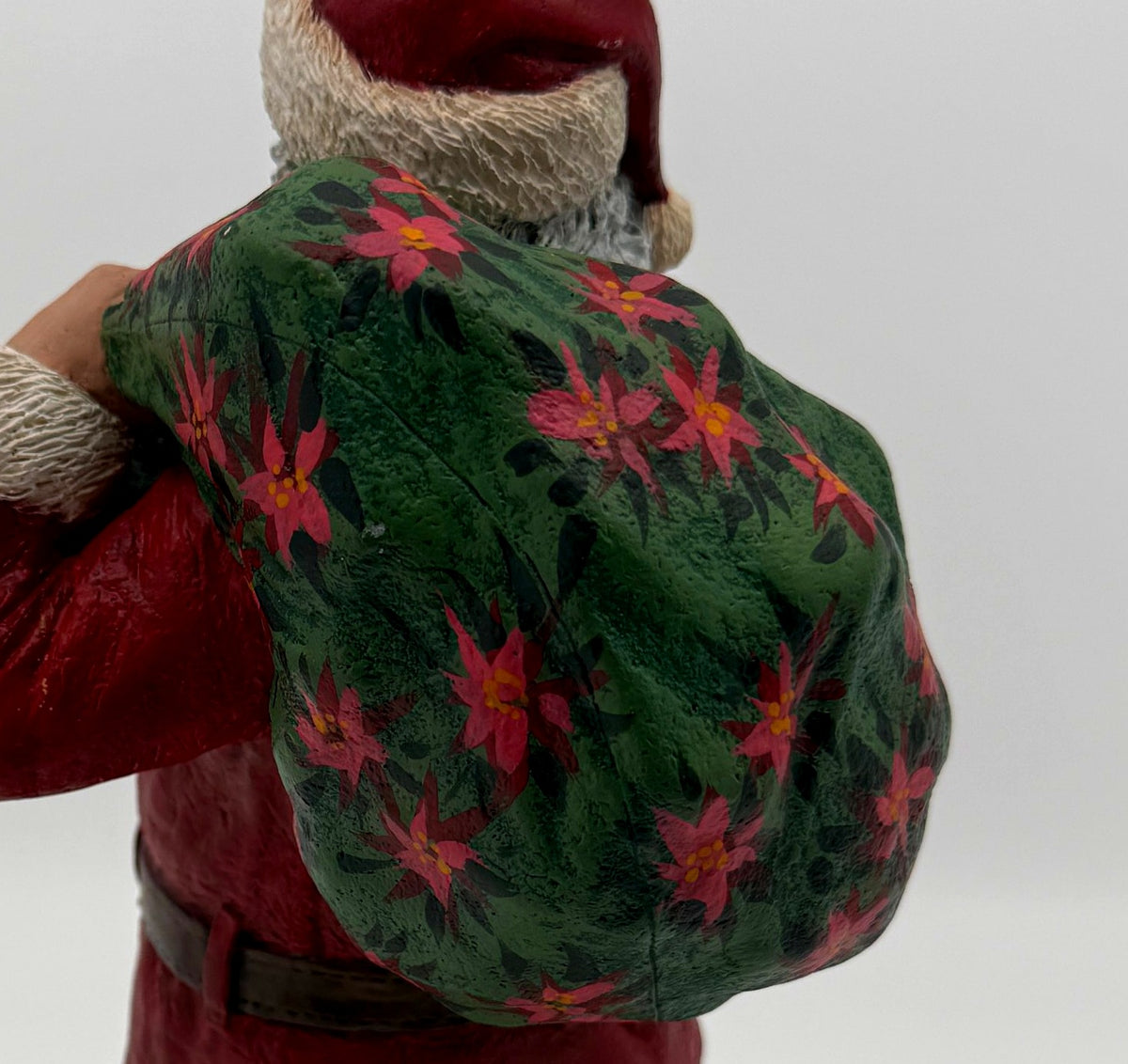 Vintage 1994 Duncan Royale Santa's Gift figurine – detail of the hand-painted poinsettia pattern on the gift sack