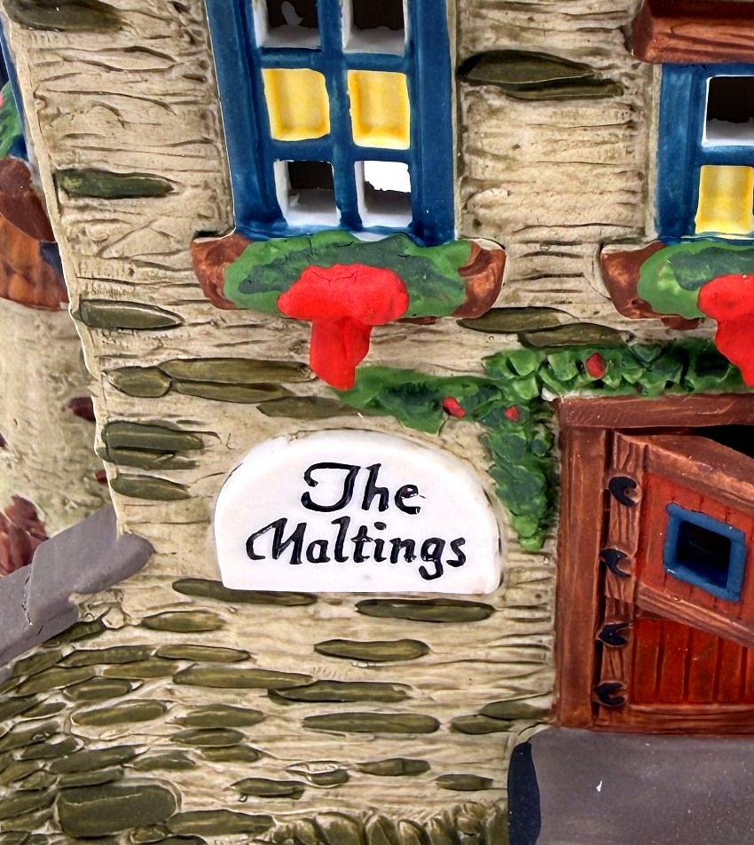 Detail of The Maltings sign, ajar front door and red-bowed window boxes