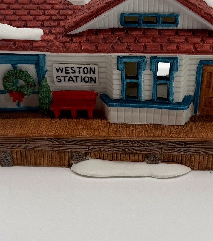 Department 56 New England Village Weston Train Station #5931-5 — detail: WESTON STATION sign, wreath, and red bench