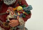 Vintage 1991 Duncan Royale Today's Nast Santa figurine – detail of the toys in Santa's arm: rocking horse, blonde doll, blue toy train and an ear of corn