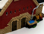 Department 56 Dickens' Village Butter Tub Barn #58338 – detail: water trough, barrels and sacks at the gable end