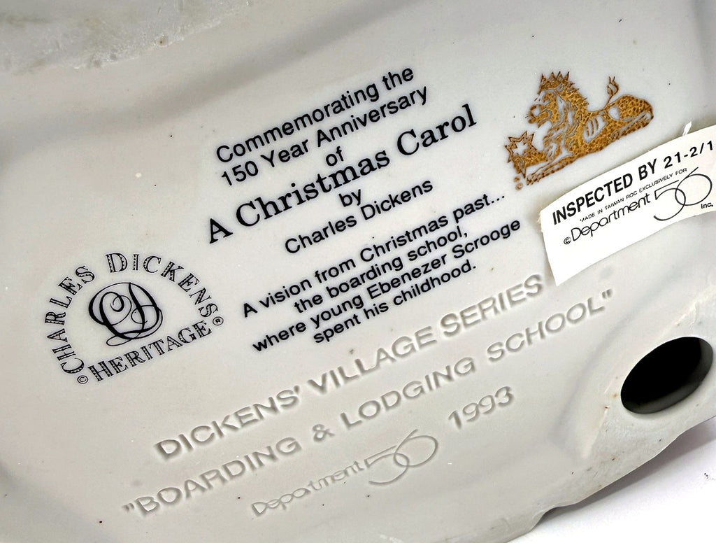 Department 56 Dickens' Village Boarding & Lodging School 1993 #5809-2 – 150th Anniversary of A Christmas Carol Commemorative Edition, No. 18 – detail of the printed underside text commemorating the 150th anniversary of A Christmas Carol, with the Charles Dickens Heritage logo