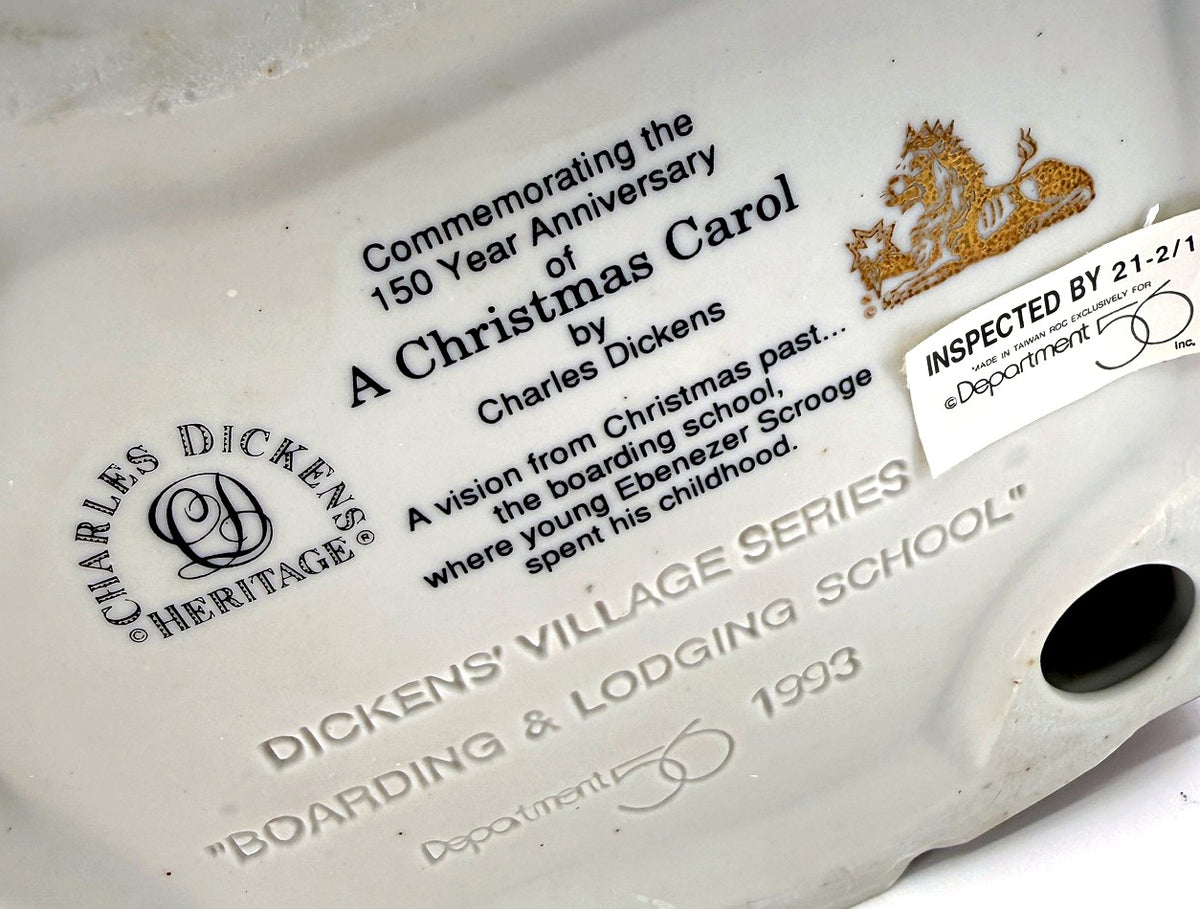 Department 56 Dickens' Village Boarding & Lodging School 1993 #5809-2 – 150th Anniversary of A Christmas Carol Commemorative Edition, No. 18 – detail of the printed underside text commemorating the 150th anniversary of A Christmas Carol, with the Charles Dickens Heritage logo