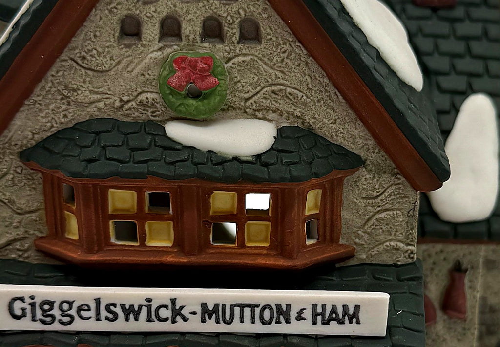 Detail of the Christmas wreath with red bow, snow-dusted bay window and hand-painted stone gable