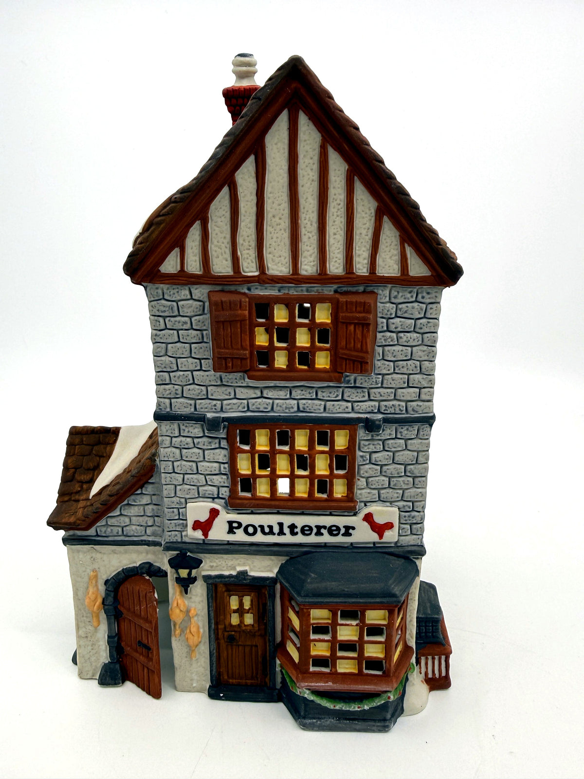 Department 56 Dickens' Village Poulterer 1988 lighted porcelain poultry shop — front view: stone poultry shop with half-timbered gable, Poulterer sign and red roosters