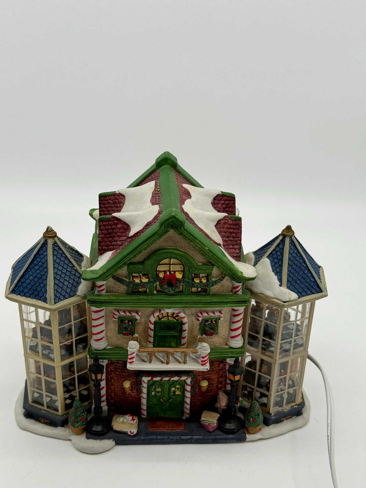 Front view of the Child's Wonder Candy Shop from a slightly high angle, showing the snow-covered roof and both glass bay towers