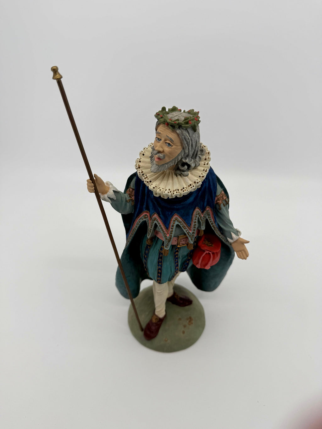 Vintage 1985 Duncan Royale Sir Christmas figurine – front three-quarter view with his original removable staff: royal blue scalloped cape, white lace ruff collar, holly wreath and red drawstring pouch; History of Santa Claus II limited edition of 10,000