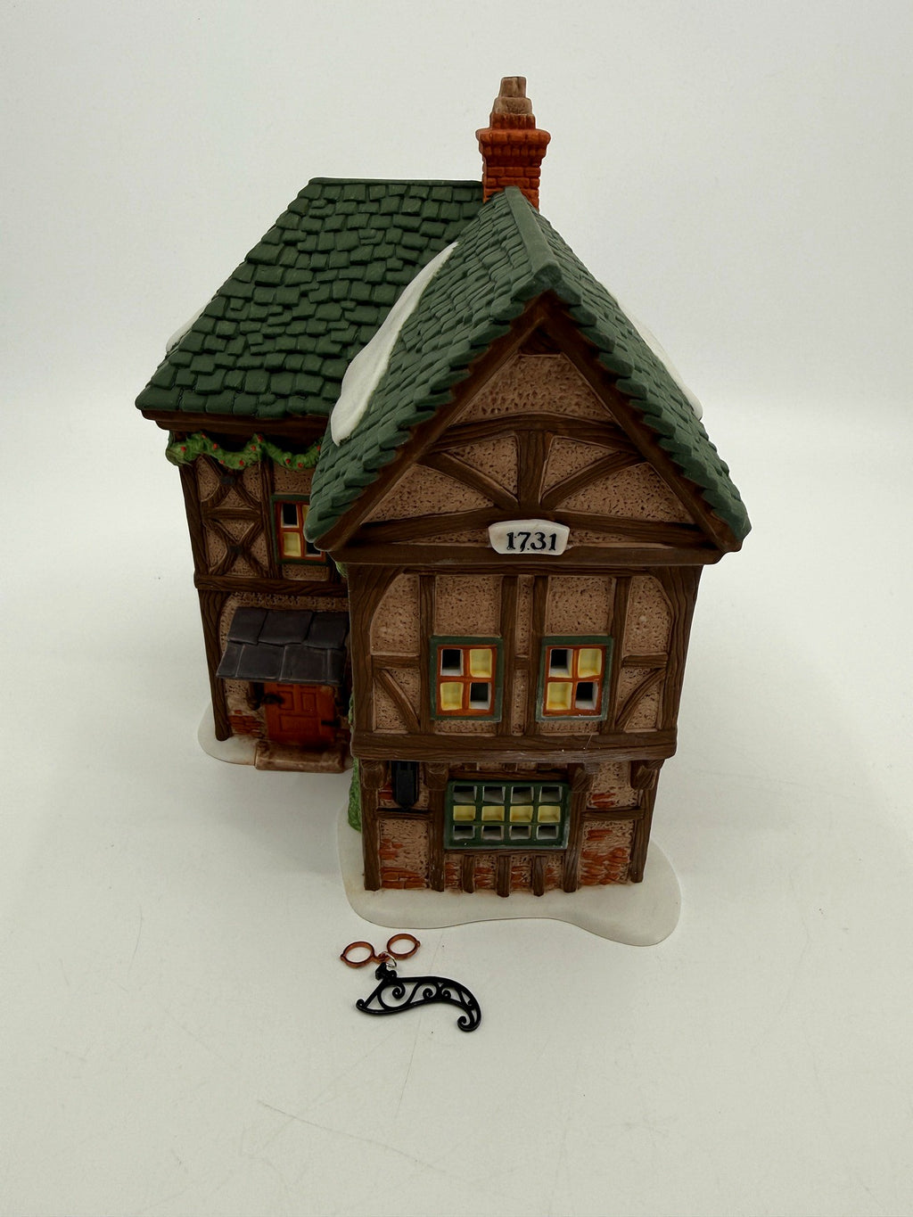 Department 56 Dickens' Village T. Puddlewick Spectacle Shop #58334 — front three-quarter view with the hanging spectacles sign and bracket