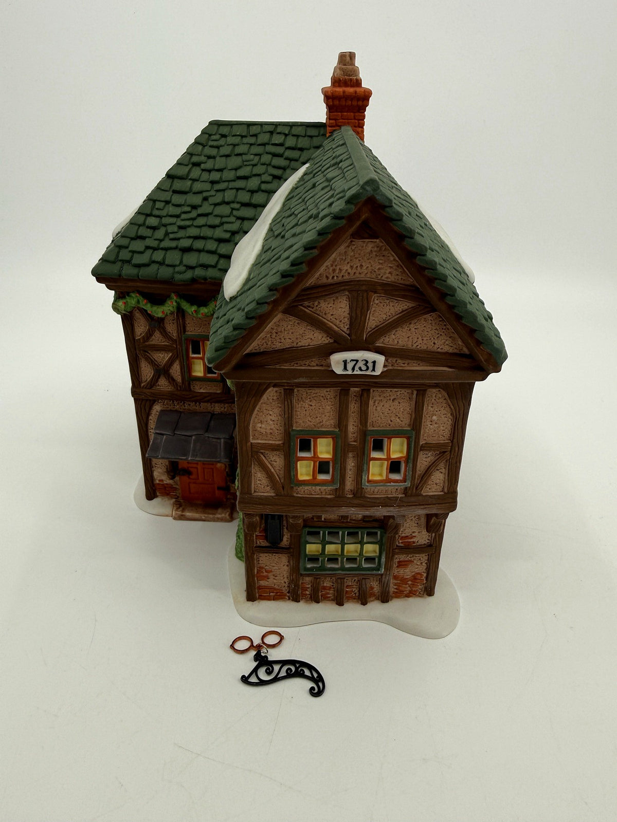 Department 56 Dickens' Village T. Puddlewick Spectacle Shop #58334 — front three-quarter view with the hanging spectacles sign and bracket