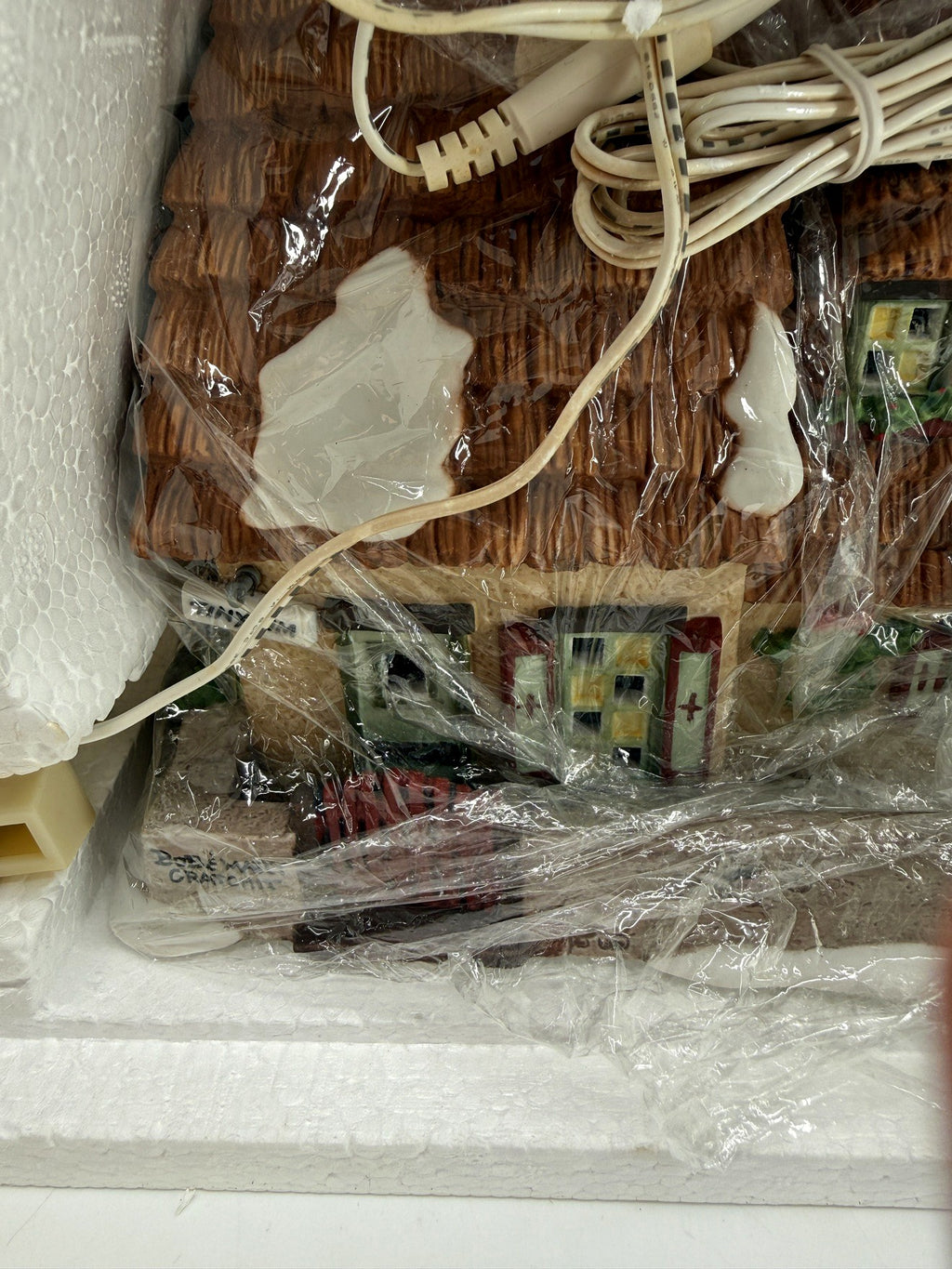 Department 56 Dickens' Village The Christmas Carol Cottage #58339 — the wrapped cottage in its Styrofoam, thatched roof and original cord visible through the packaging