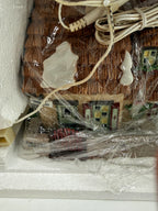 Department 56 Dickens' Village The Christmas Carol Cottage #58339 — the wrapped cottage in its Styrofoam, thatched roof and original cord visible through the packaging