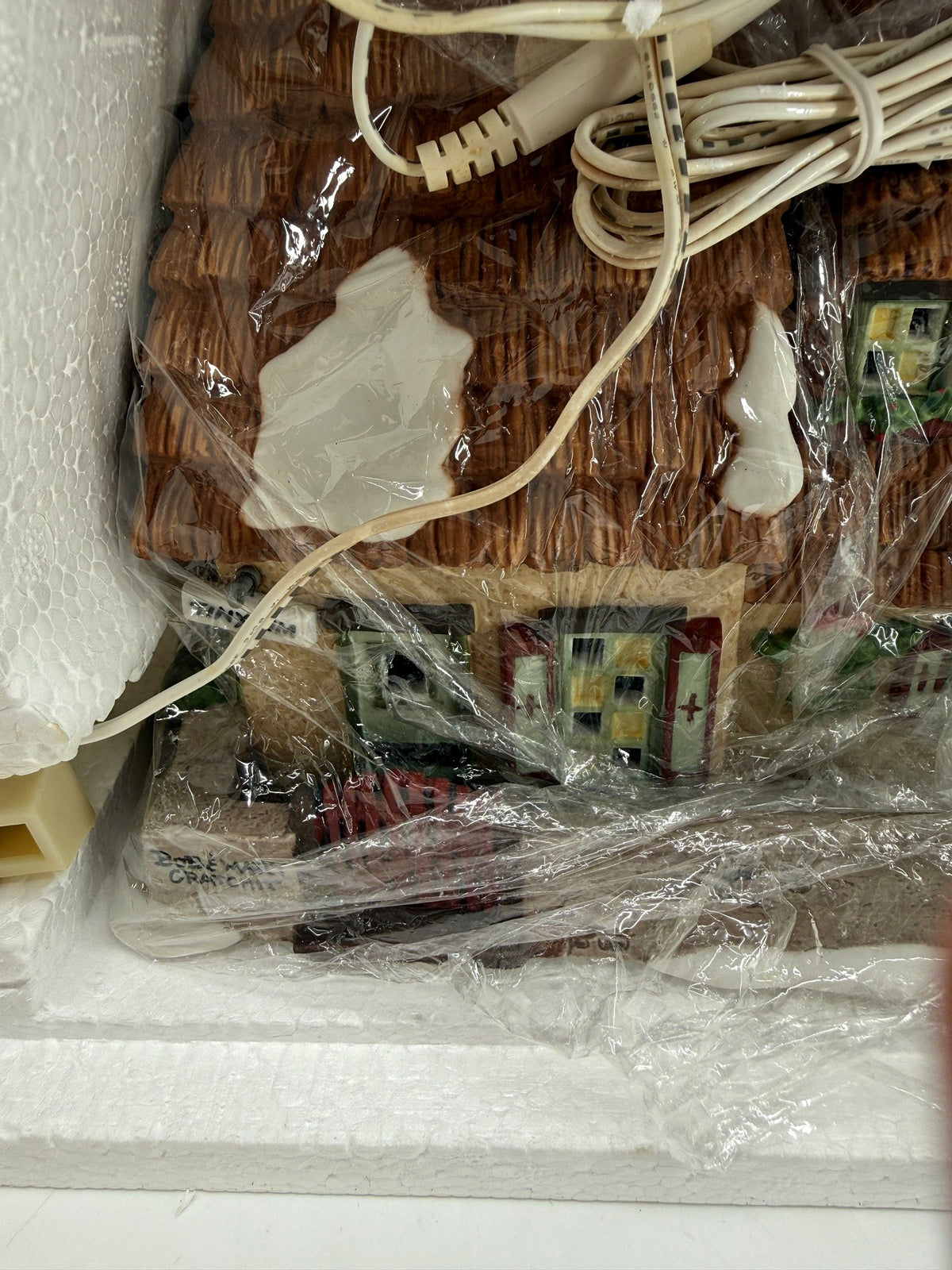 Department 56 Dickens' Village The Christmas Carol Cottage #58339 — the wrapped cottage in its Styrofoam, thatched roof and original cord visible through the packaging