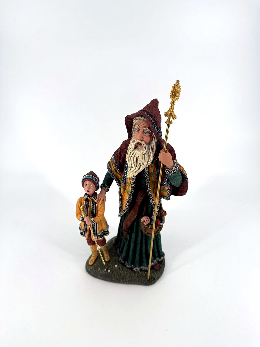 Three-quarter front view — burgundy hooded cloak, forest green robe and the pouch of miniature toys