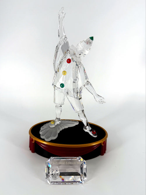 1999 Swarovski SCS Pierrot Masquerade crystal figurine — the figurine on its round display base with the crystal title block in front