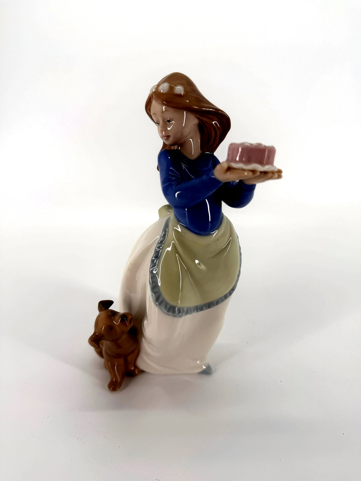 NAO by Lladro Puppy's Birthday 1045 porcelain figurine — front three-quarter view — the girl holding a tray with a pink cake, puppy at her feet
